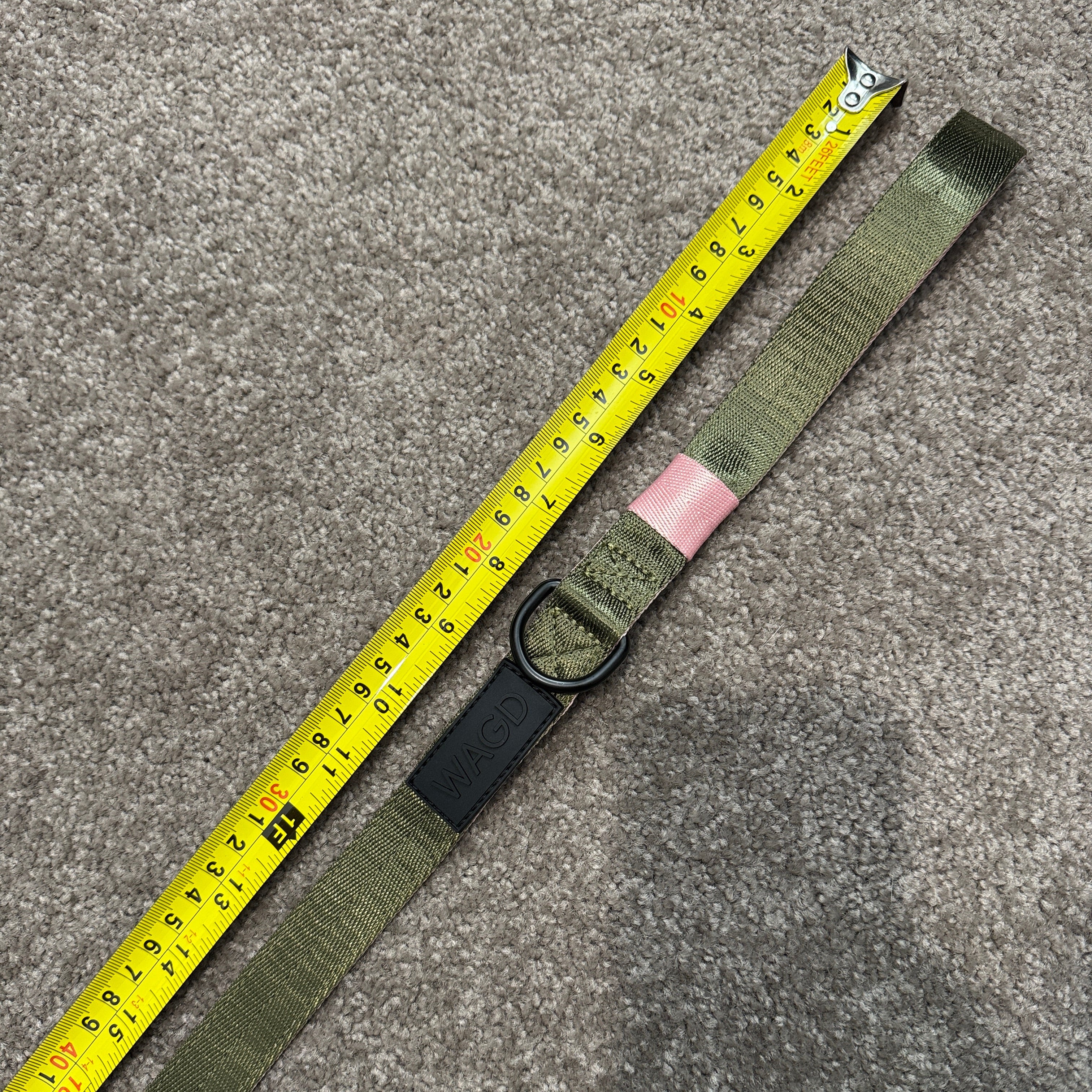 Green belt with a measuring tape draped over it on a gray surface