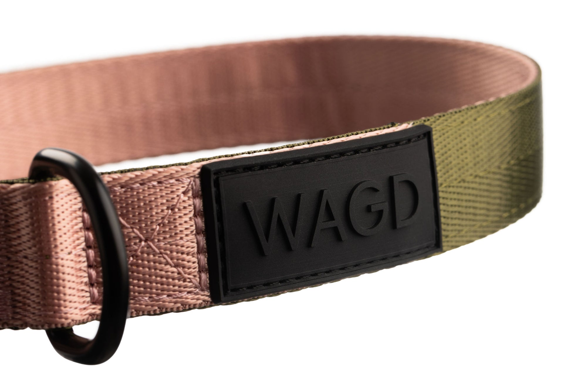 Close up of dog collar logo. Black rubber with raised black letters WAGD.
