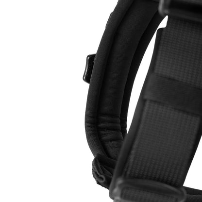 Close-up of a black padded dog harness strap on a white background